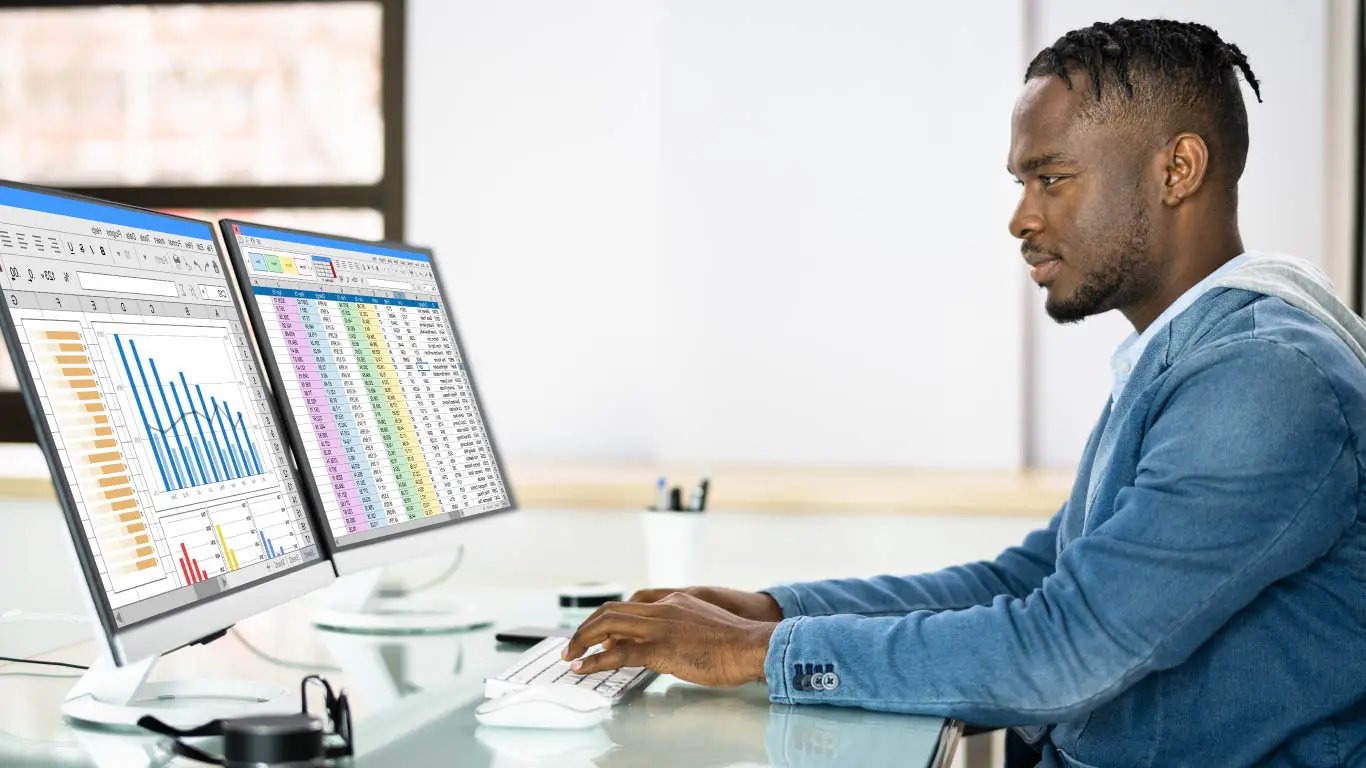 Man working on screen with reports and analytics