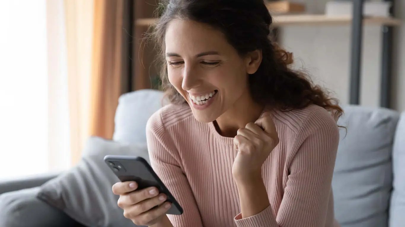 Satisfied customer happy looking at smartphone