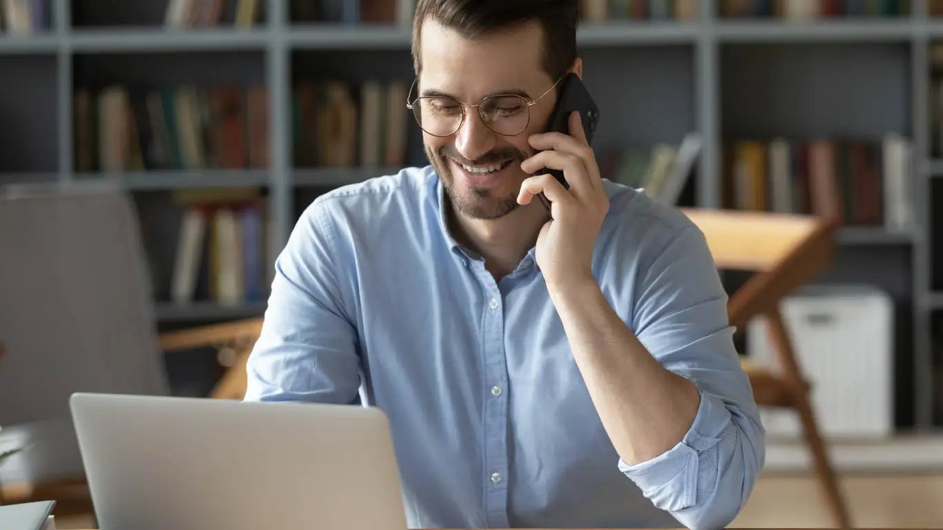 Happy man on phone and laptop