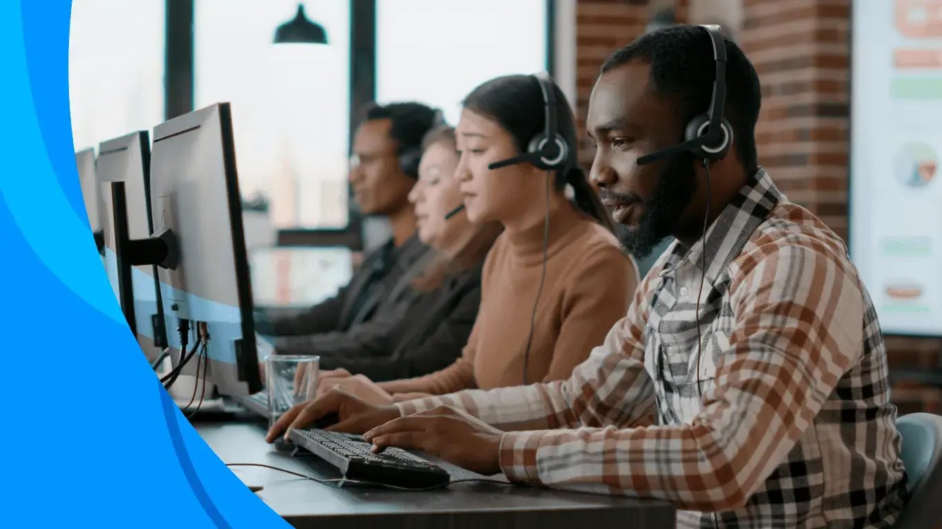 Row of contact center agents wearing headsets and working at computers in a modern office setting