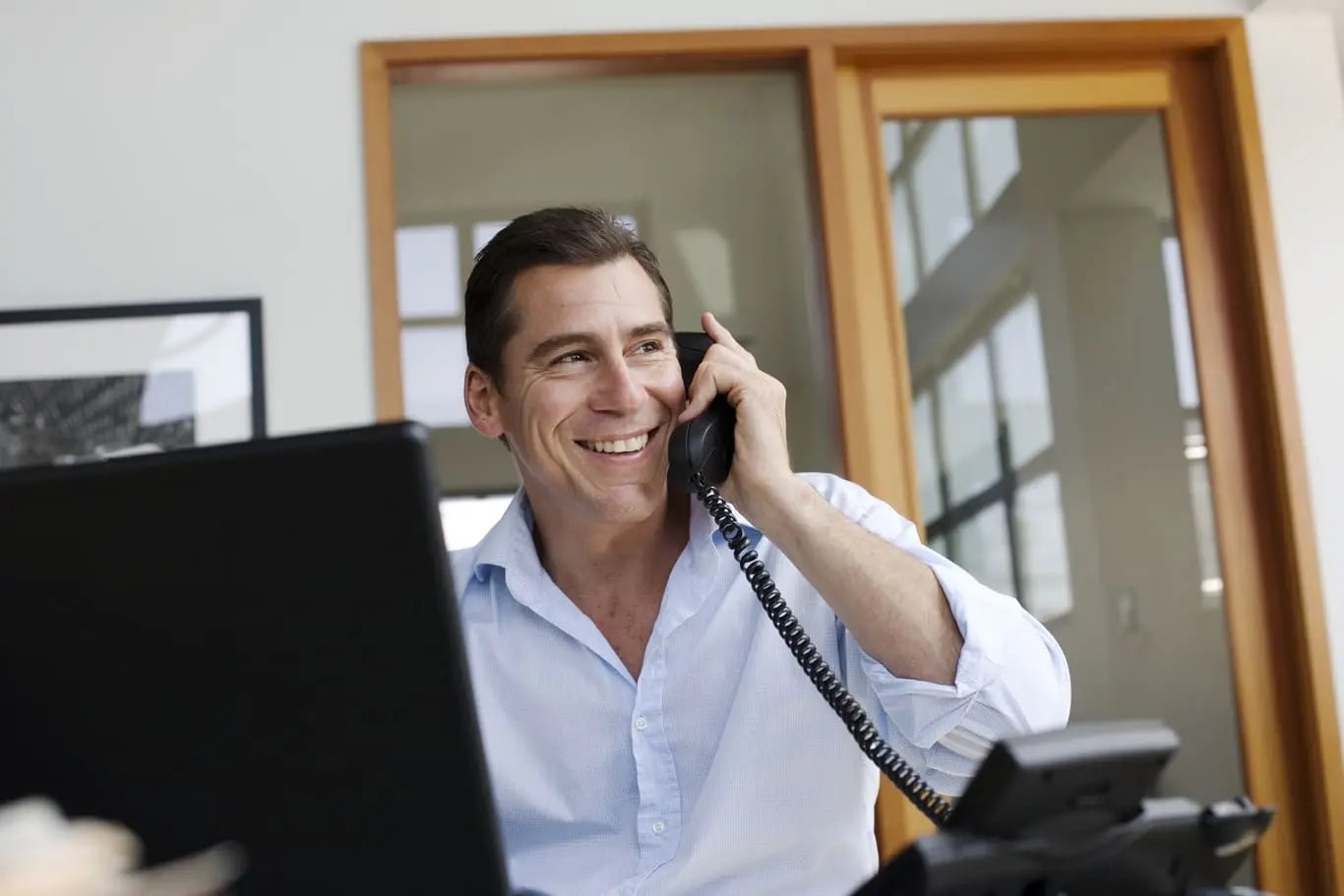 man-talking-on-a-telephone-while-smiling