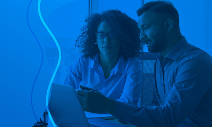 manager and employee looking at work on computer